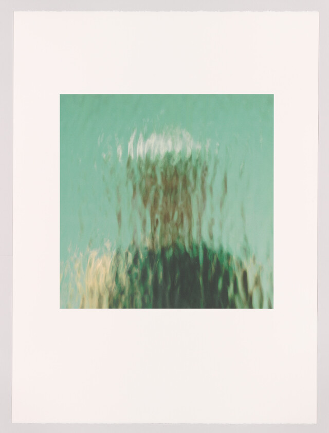 A blurred silhouette seen through rippled glass, creating distorted vertical streaks.