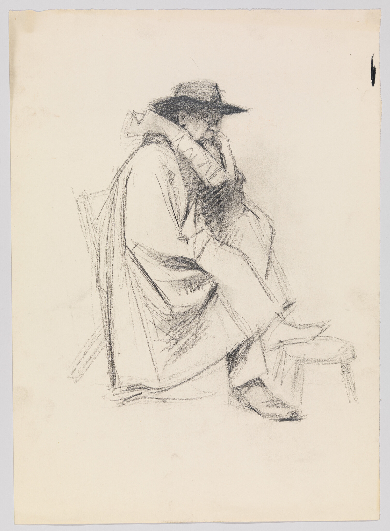 A man in a wide-brim hat and cloak sits leaning forward with his foot on a stool.