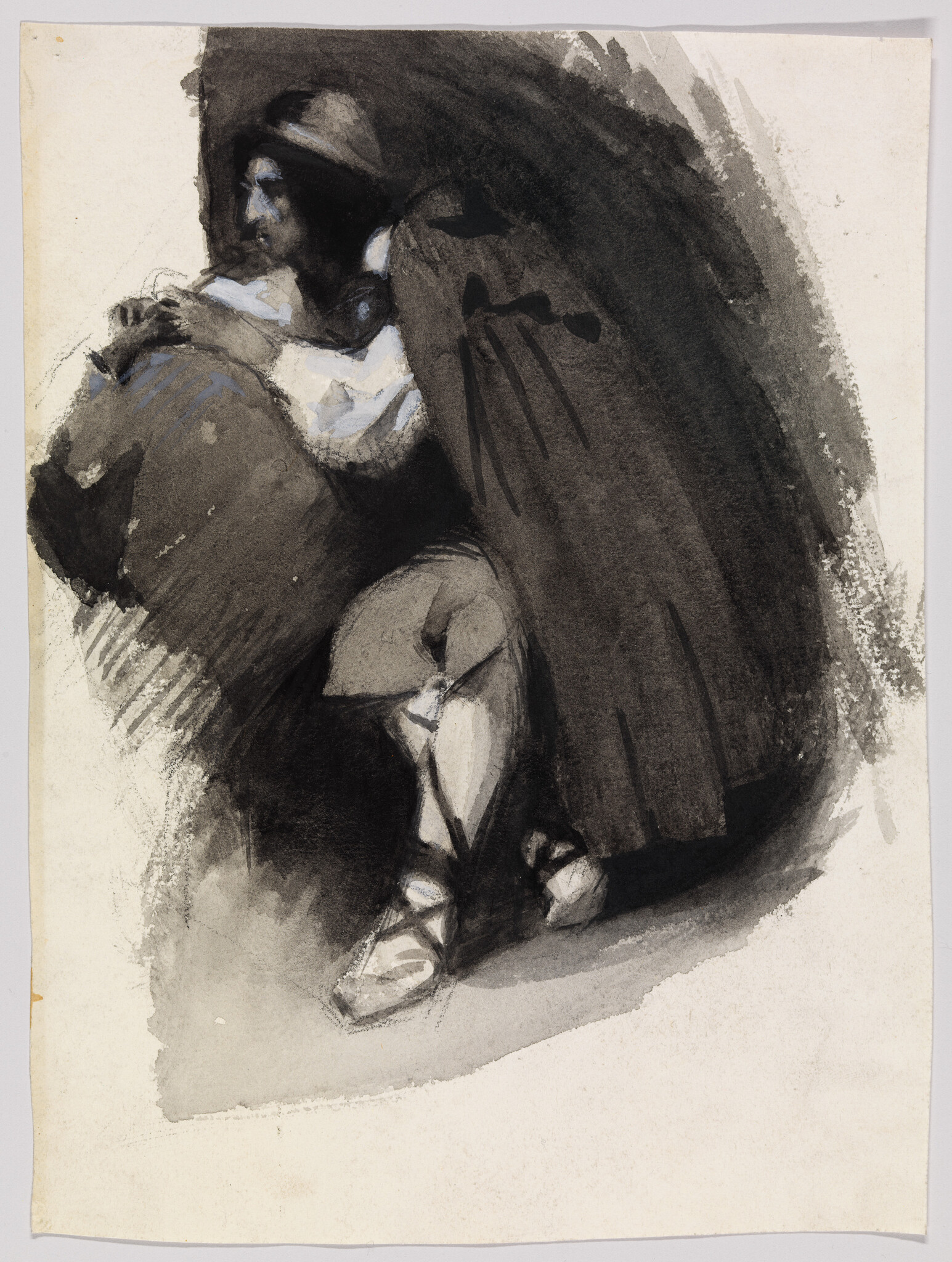 A cloaked man kneels and leans over a large sack in shadow.