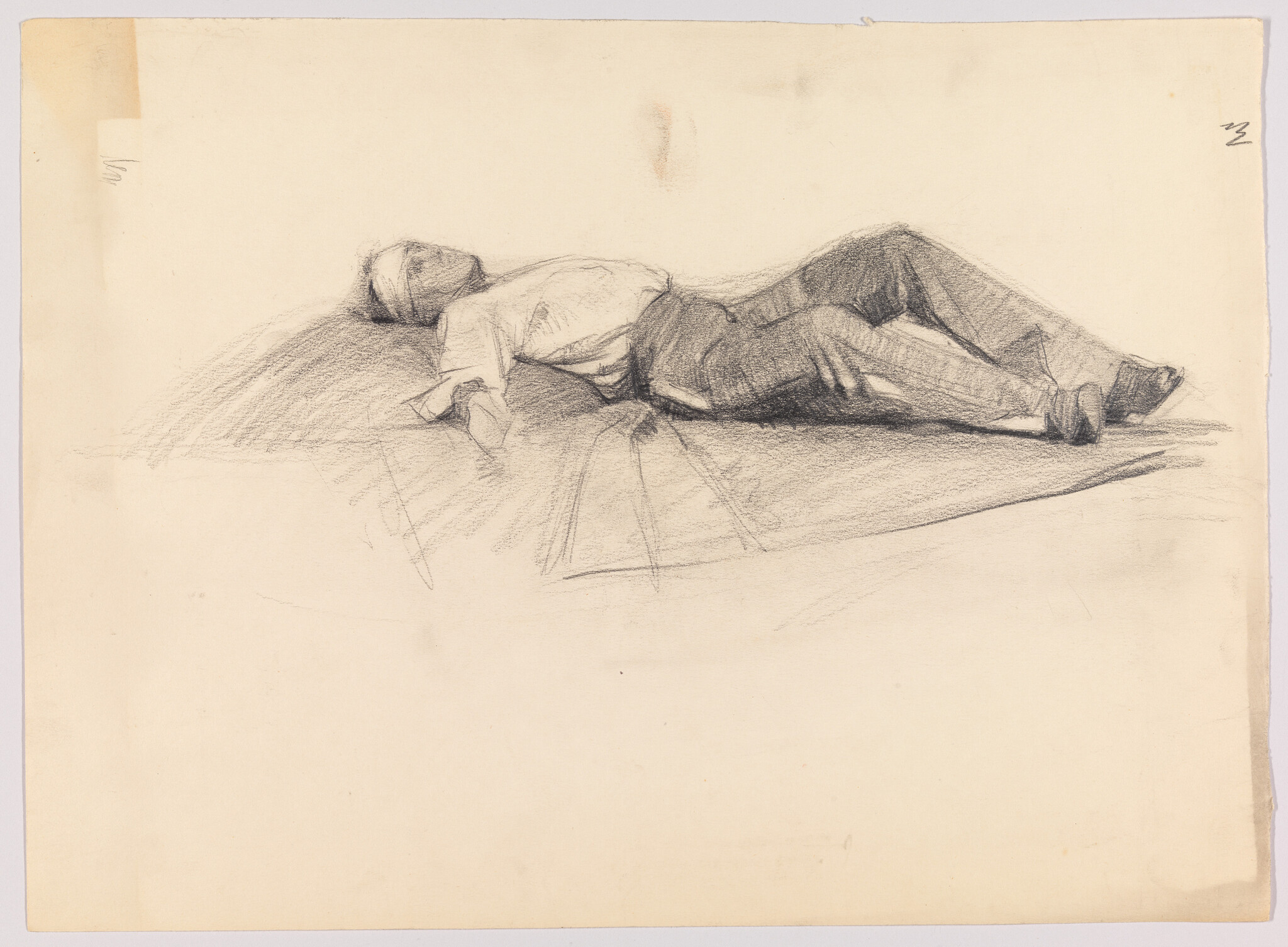 A man lies on his back on the ground with legs slightly bent.