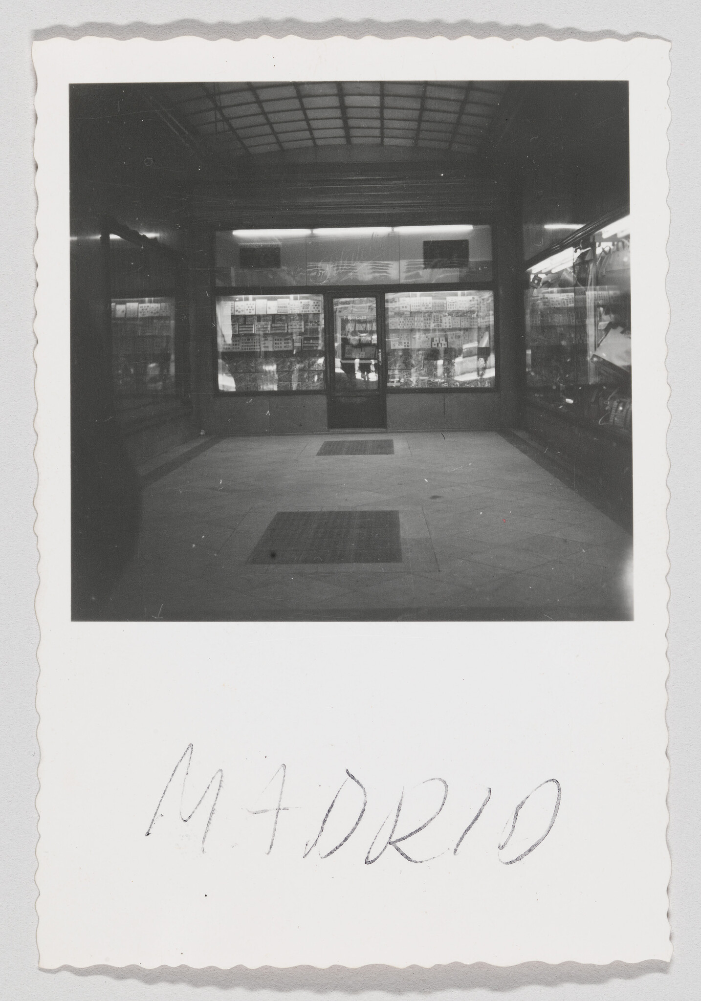 Entrance to a shop with glass display windows and Madrid handwritten below.