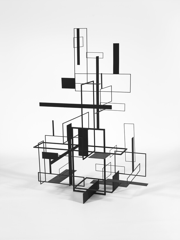 Abstract black metal sculpture of intersecting rectangular frames and bars on a white background.