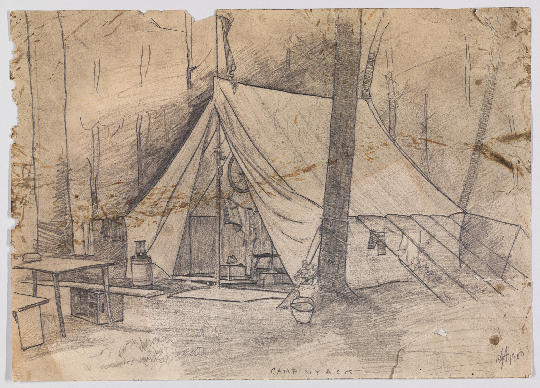 Large canvas tent set up among trees with table, bucket, and camp gear outside.
