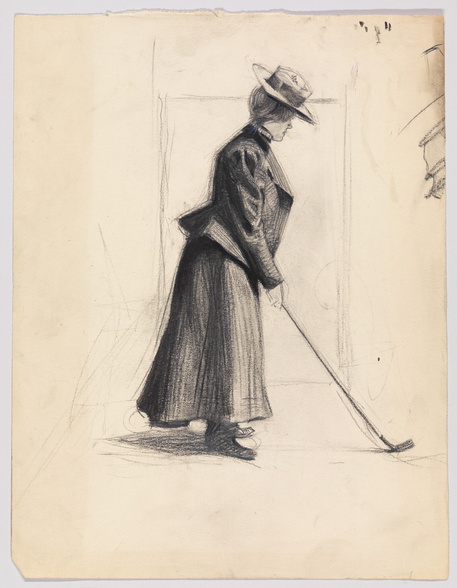A woman in a long skirt and hat leaning forward while holding a curved club.
