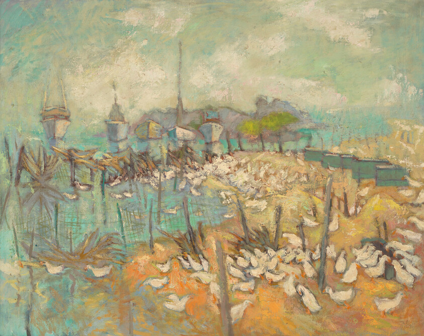A flock of white ducks gathers along a shoreline with boats and distant buildings.