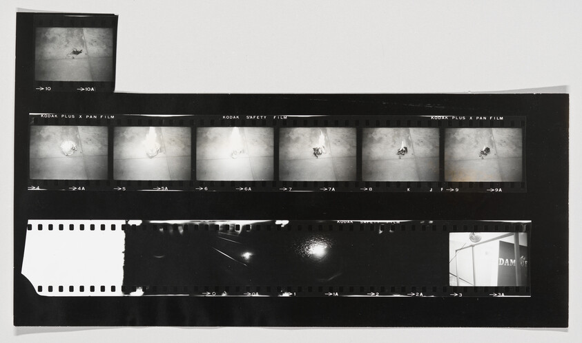 Contact sheet of black-and-white film negatives showing a small object on a tiled floor across multiple frames.