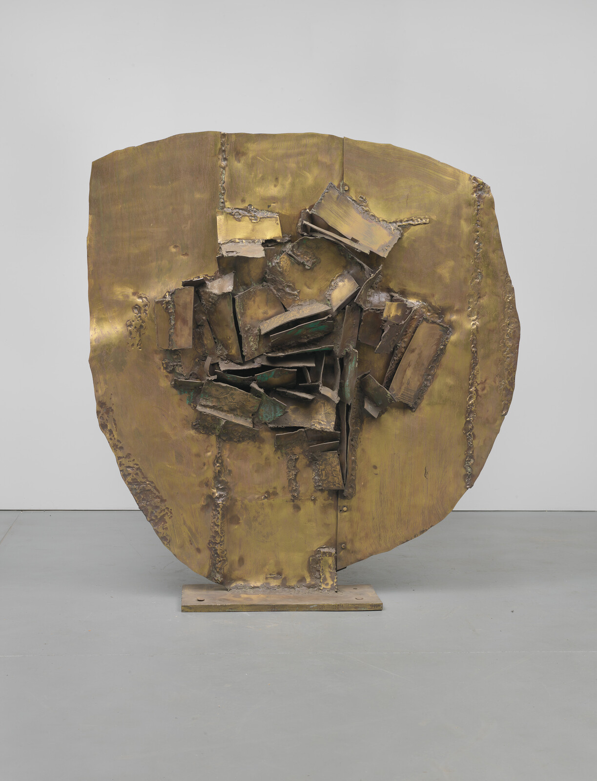 Large round bronze sculpture with clustered jagged metal plates welded into a central cavity.