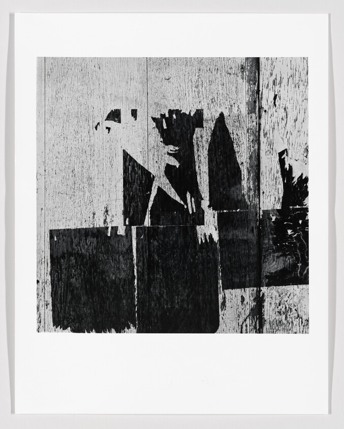 High-contrast black and white abstract print showing peeling paint and rectangular wood panels.