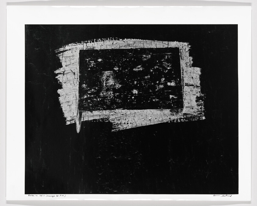 Rough rectangular white paint with textured marks stands against a large black background.