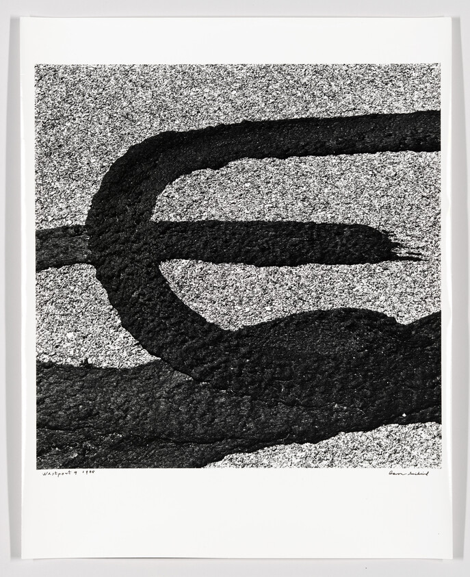 Thick black brushstroke forms a looping shape across a speckled gray textured background.