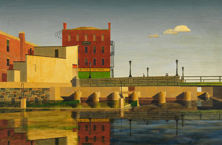 Red brick factory and waterfront buildings reflect clearly in calm river by a quiet riverside walkway.