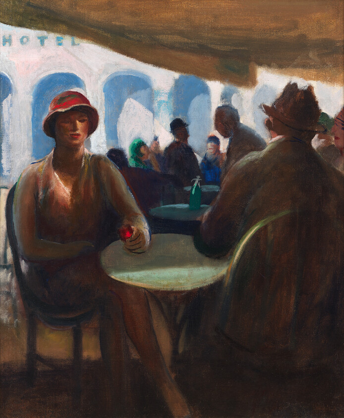 A woman in a red hat sits at a café table holding a small red flower while others talk.