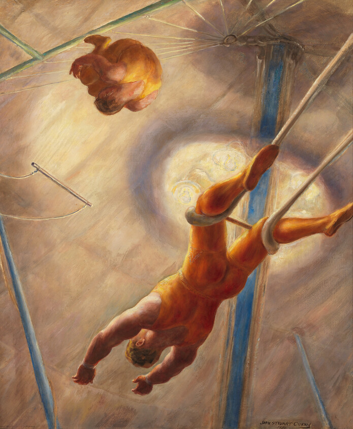Two trapeze artists in orange leotards perform midair, one swinging on a bar while the other flips.