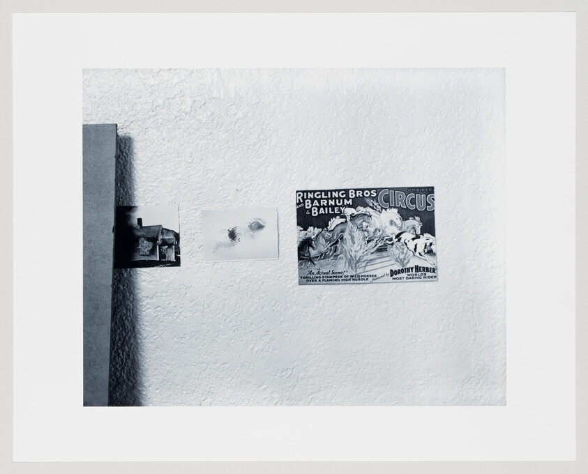 Three small pictures are tacked to a textured wall, including a vintage Ringling Bros. circus poster.