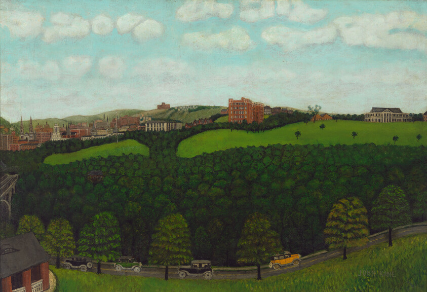 A green park and wooded hillside with vintage cars driving along a road toward a distant city skyline.