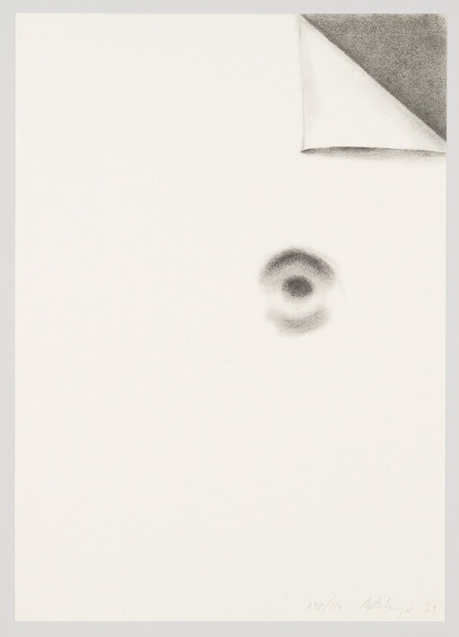 A mostly blank sheet of paper with a curled top-right corner and a small dark circular smudge.