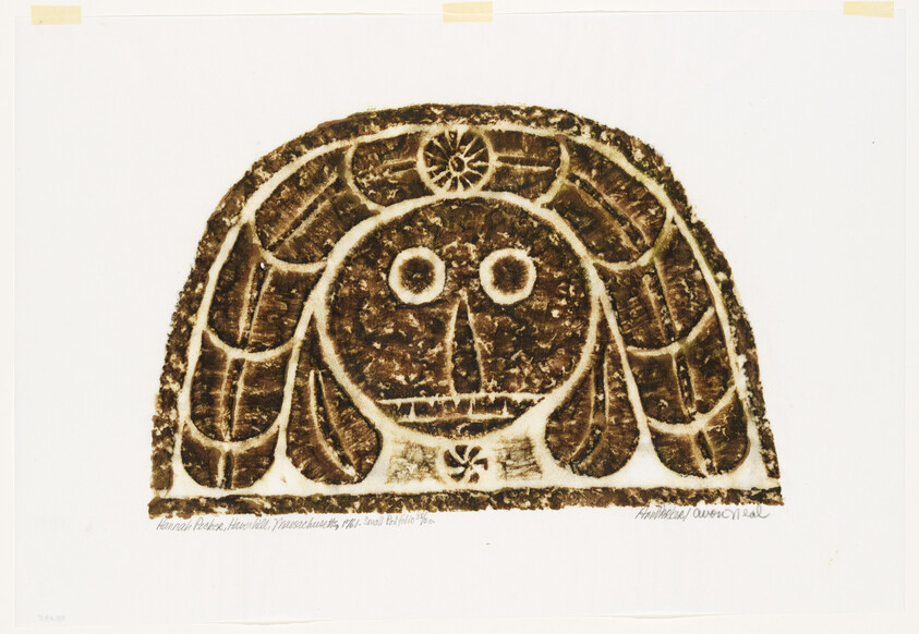 Stylized brown carved face with round eyes and patterned hair on a white background.