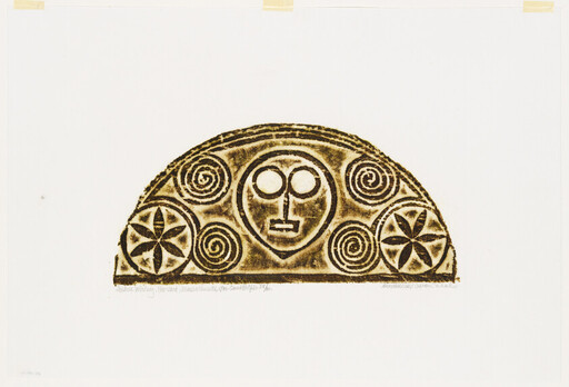 A semicircular carved panel showing a central stylized face surrounded by spiral and star motifs.