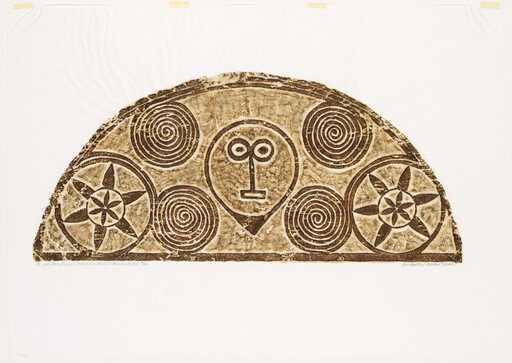 A semicircular carved panel featuring a central stylized face surrounded by spiral motifs and star rosettes.