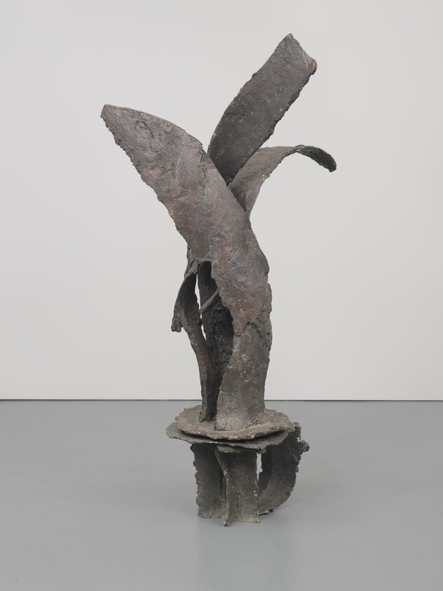Tall abstract bronze sculpture with curved, leaf-like forms rising from a round base.