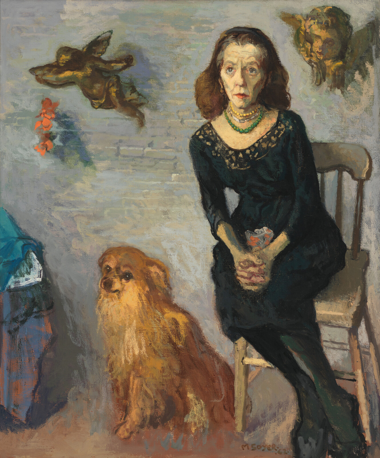 An older woman in a black dress sits with hands clasped while a small fluffy dog sits beside her.