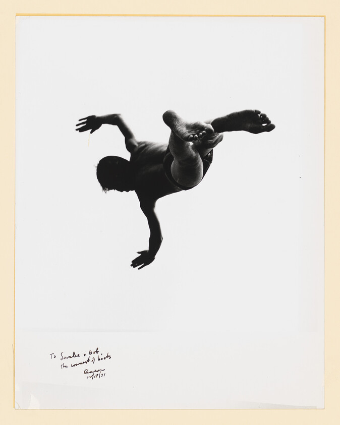 Silhouette of a person twisting mid-air with legs crossed and arms outstretched.