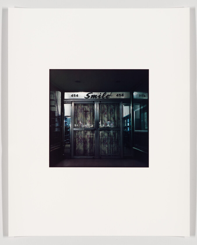 A photograph of a storefront with the word "Smile" written across the top, flanked by the numbers 454. The store's display windows are covered with curtains, and the entrance appears dark and uninviting. The image is centered within a large white border.