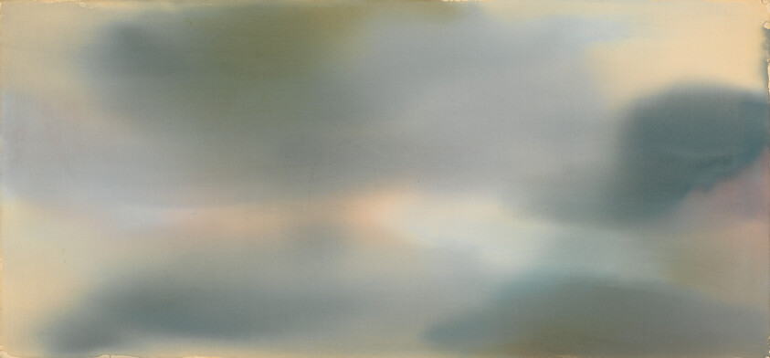 A soft, blurred sky with large muted gray and blue cloud shapes.