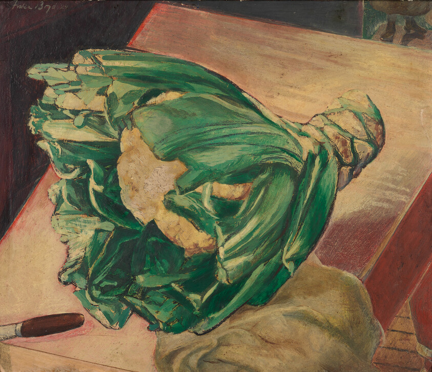 A head of green lettuce lies on a wooden table beside a knife and cloth.