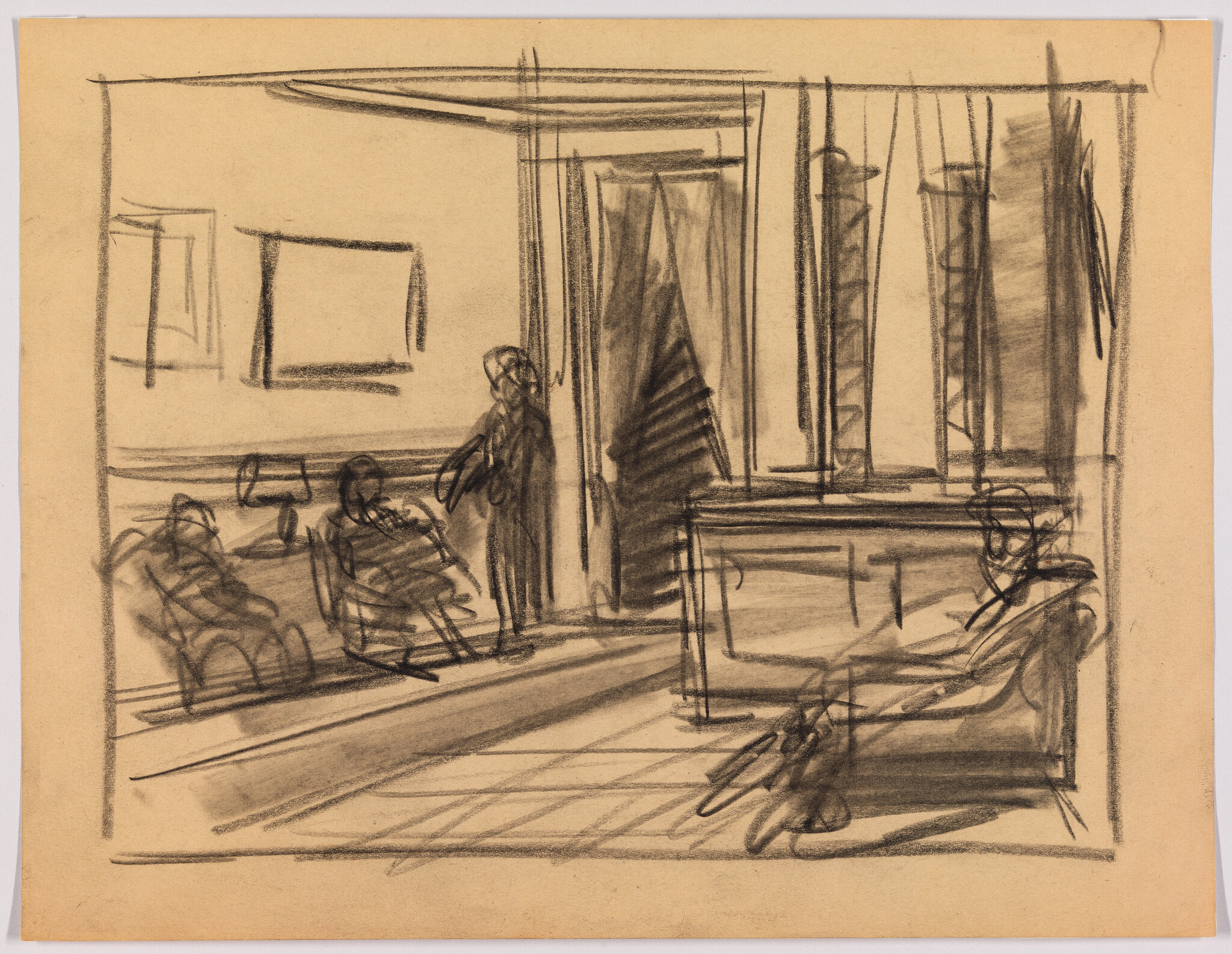 Three seated people and one standing person in a sparse room with a desk and tall windows.