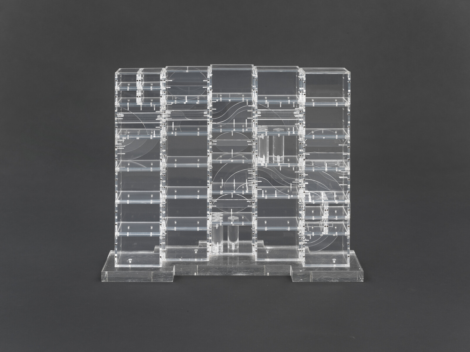Clear acrylic modular shelving unit with multiple square compartments and curved internal channels.
