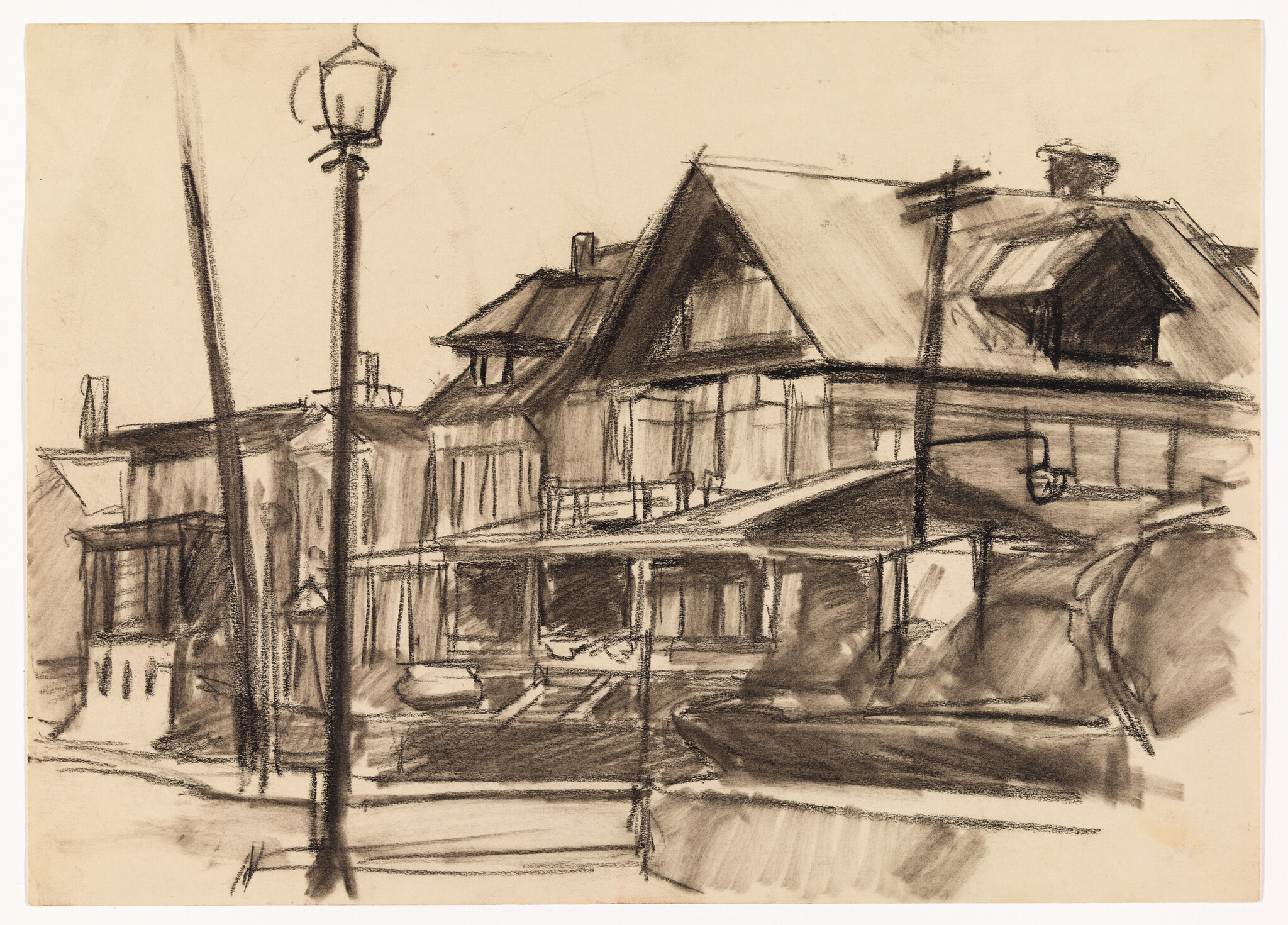 Two-story houses with steep roofs and a tall streetlamp standing in front.