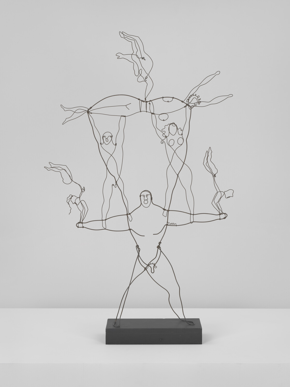 Wire sculpture of a strongman balancing multiple acrobats stacked above him.