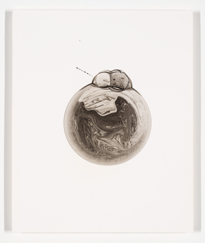 A marbled circular bubble with two small connected bubbles rests centered on a white background.