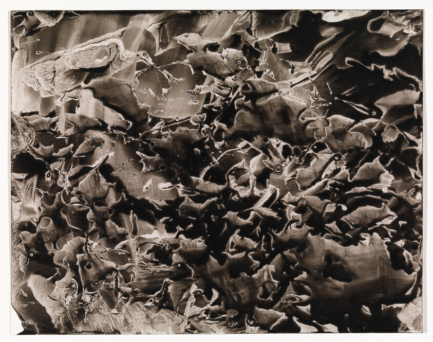 Dark abstract marbled pattern with swirling ink-like shapes and textured highlights across the surface.