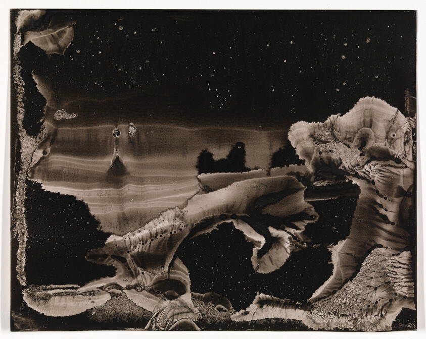 Abstract black-and-white ink wash with swirling shapes resembling a rugged landscape under speckled sky.