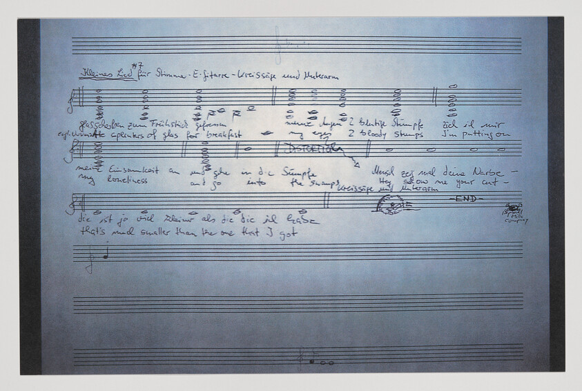 Handwritten musical score on staff paper with notes, chords, and mixed English and German lyrics.