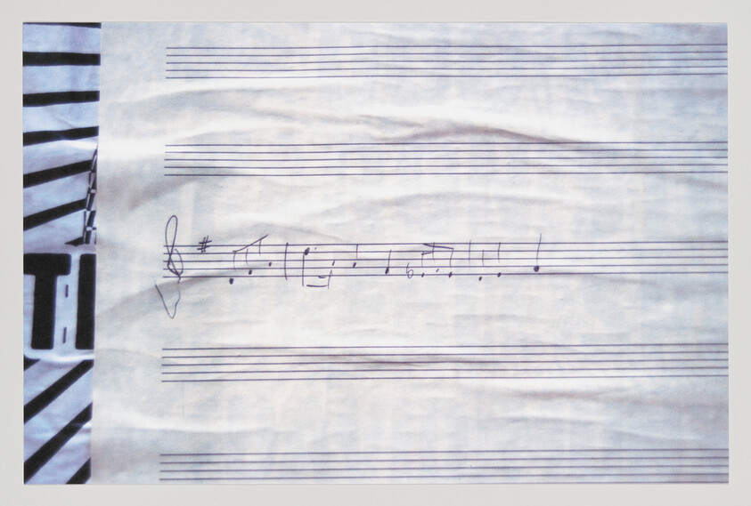 A sheet of staff paper with a short handwritten treble-clef melody in ink.