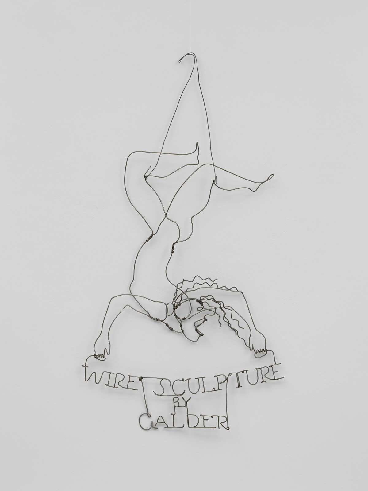 A hanging wire sculpture shows an acrobat doing a handstand above the words "Wire Sculpture by Calder."