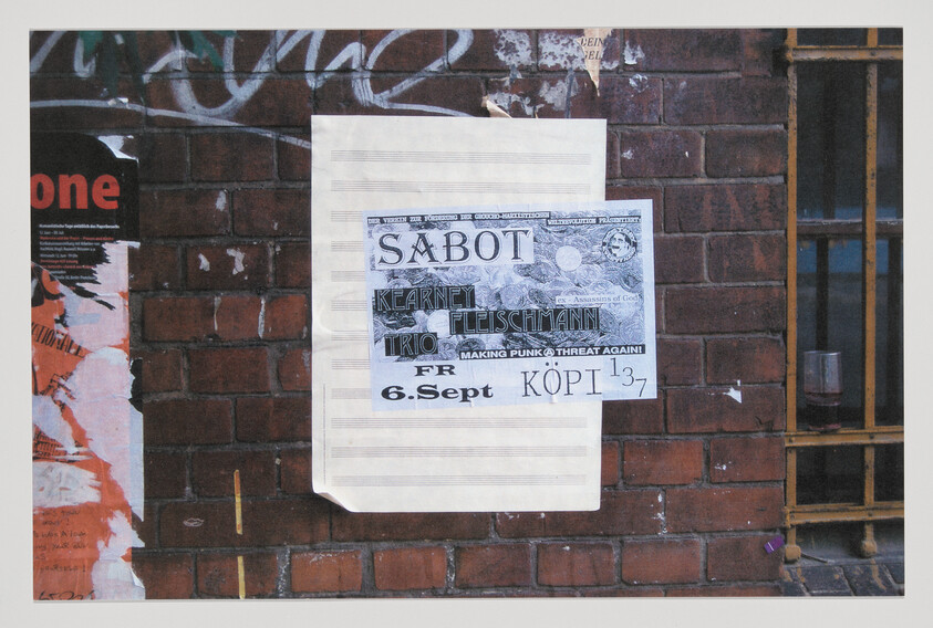 A concert poster for Sabot and Kearney Fleischmann dated 6. Sept pasted on a brick wall.