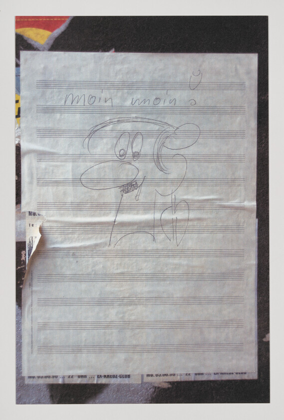 Hand-drawn cartoon dog face doodle and the words "moin moin" on lined music paper.