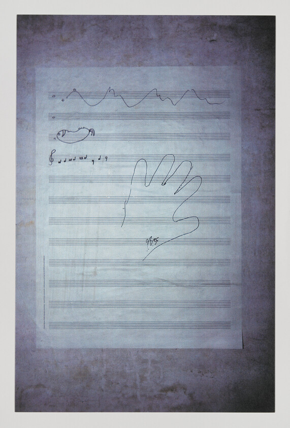 Music staff paper on wall with a drawn hand outline and small musical notations.