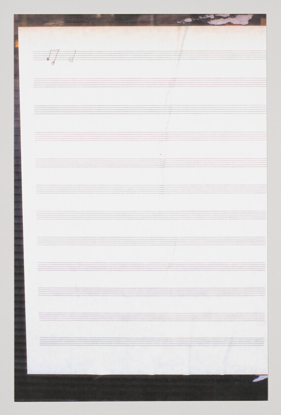 Blank sheet of staff paper with two small handwritten musical notes in the top-left corner.