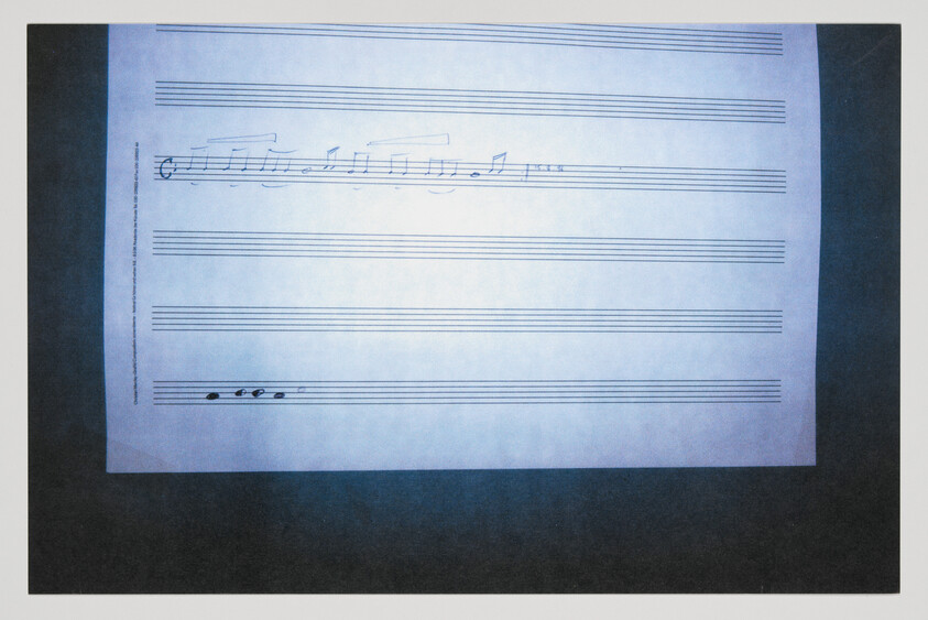 A sheet of staff paper with a short handwritten melody near the top and a few notes at the bottom.
