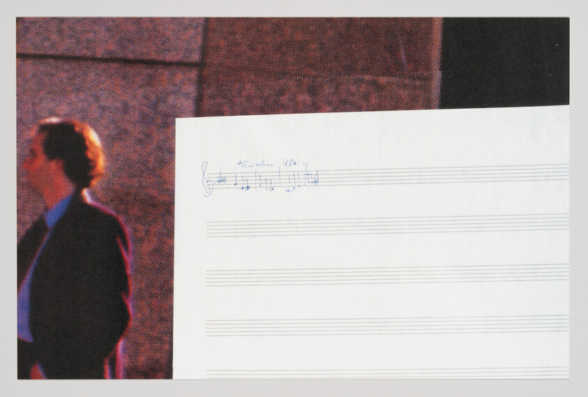 Blank music manuscript with a short handwritten melody in the top left and a blurred man standing nearby.