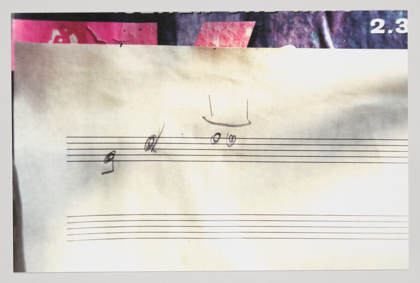 Blank sheet music with staff lines and pencil doodles including a small smiling face.