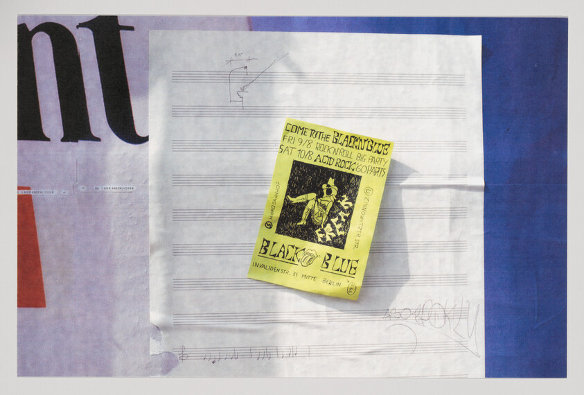 Yellow concert flyer pinned on folded sheet music against a colorful background.