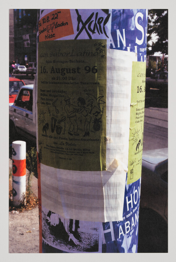 A street pole covered with layered event posters and flyers, including a visible "16. August 96" date.