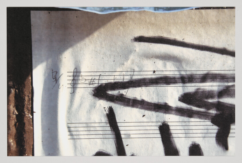 Sheet music with heavy black brush strokes and scribbled notes across the staff lines.