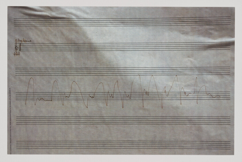 Sheet music paper with a continuous hand-drawn waveform-like line across the staff lines.